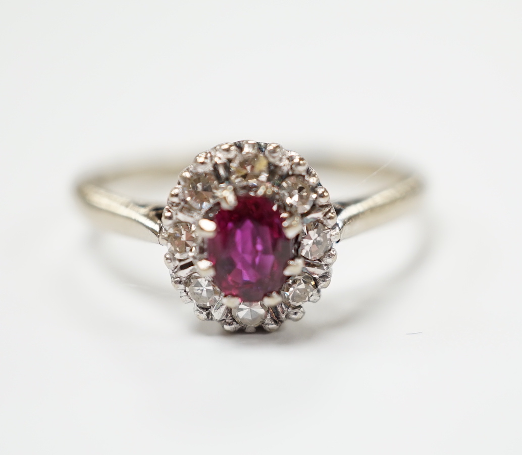 A 18ct white, ruby and diamond set oval cluster ring, size Q/R, gross weight 4.2 grams.